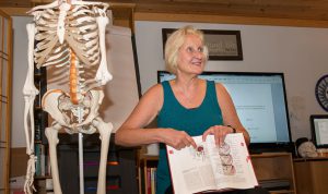 Donna Bajelis points to an anatomy illustration in a text book.