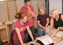 Donna Bajelis demonstrates on a patient's leg for a small group of structural integration students.